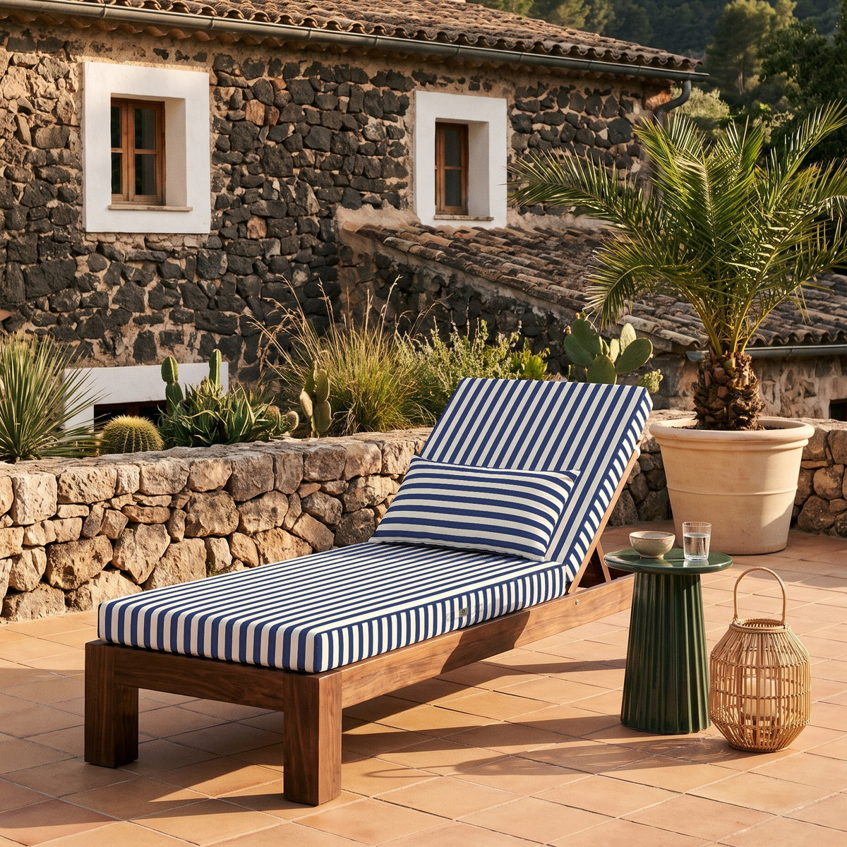 Colchoneta premium para tumbona 190x60, rayas azul marino, sobre una tumbona de madera en una terraza de piedra en Mallorca