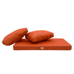 Ensemble de coussins orange pour salon de jardin, déhoussables et anti-UV, comprenant un coussin d'assise et deux dossiers.