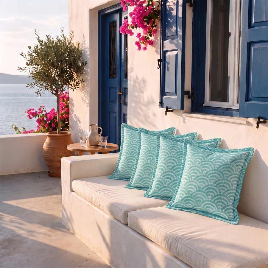 Lot de 4 coussins déco 45x45 motif Éventails Verts sur une banquette de terrasse face à la mer