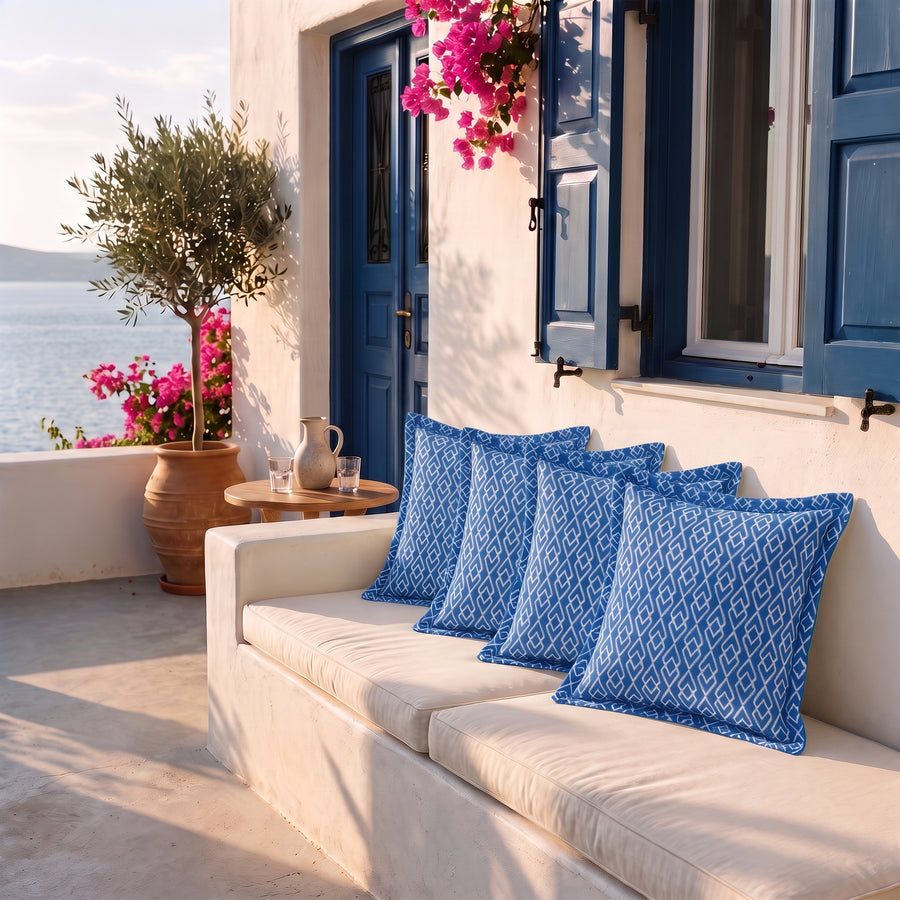 Lot de 4 coussins déco 45x45 motif Géométrique Vert sur une banquette de terrasse face à la mer